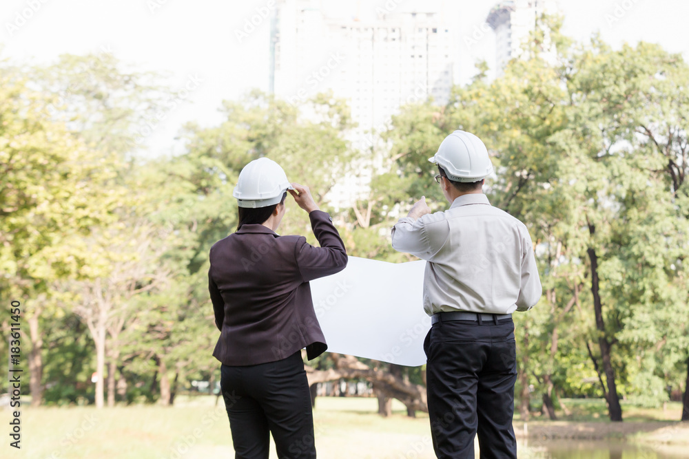 asian men and women engineers work on plans construction in the park asian men and women engineers work on plans construction in the park