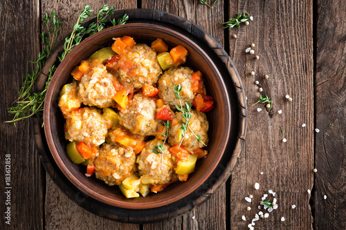 Meatballs stewed with vegetables on wooden table, top view