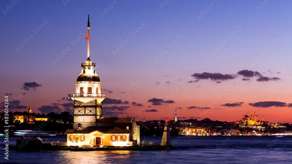 Maiden Tower or Kiz Kulesi with floating tourist boats on Bosphorus in Istanbul at night Maiden Tower or Kiz Kulesi with floating tourist boats on Bosphorus in Istanbul at night