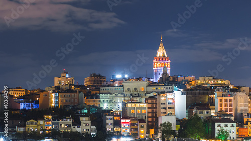 Istanbul cityscape with Galata Tower and floating tourist boats in Bosphorus night