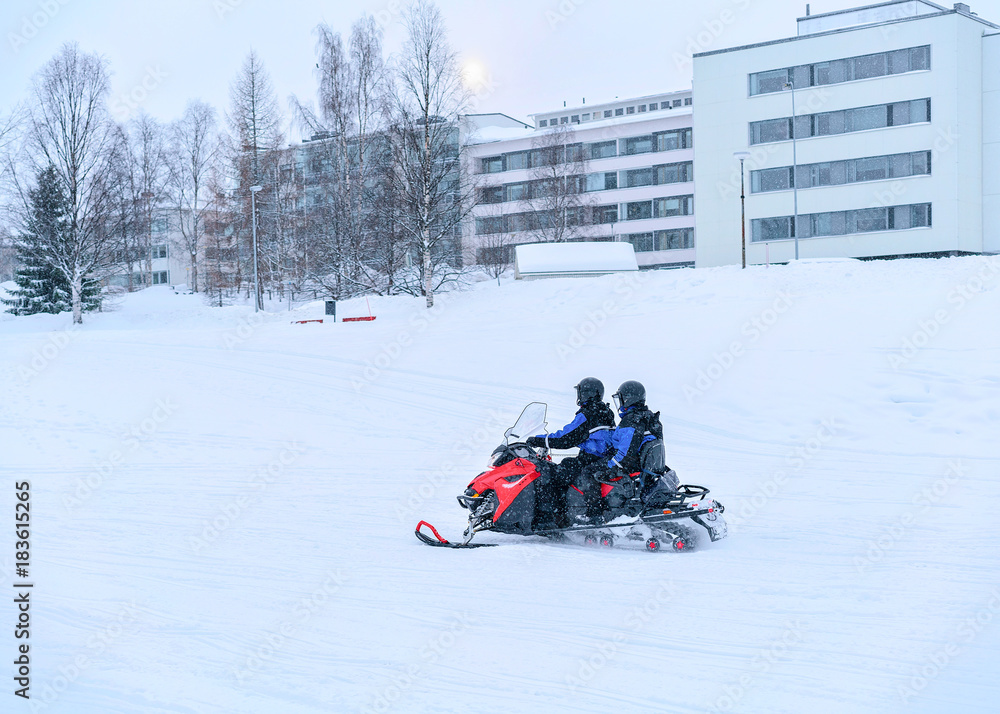 People ride snowmobile on frozen snow lake in winter Rovaniemi