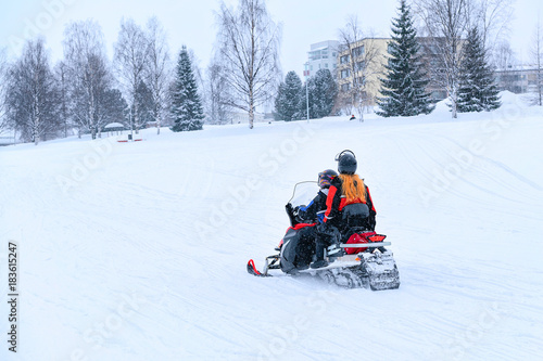 People riding snowmobile at frozen snow lake in winter Rovaniemi © Roman Babakin