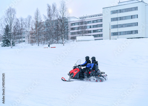 People ride snowmobile on frozen snow lake in winter Rovaniemi
