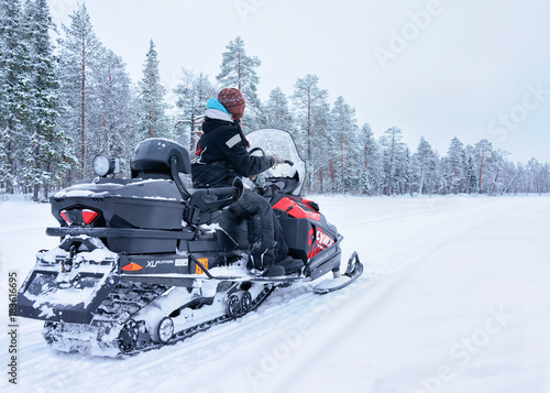 Woman riding snowmobile frozen lake winter Rovaniemi Finland