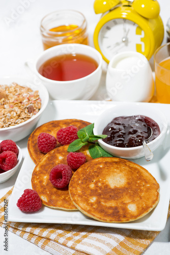 delicious pancakes with fresh raspberries and jam for breakfast, vertical closeup