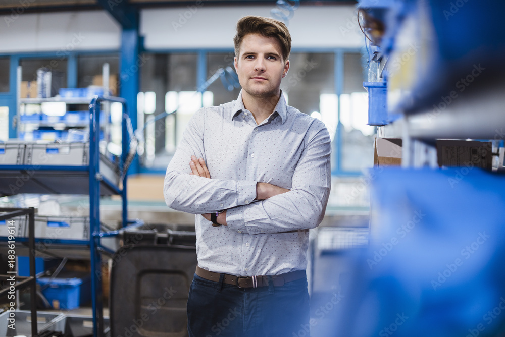 Portrait of a young manager in the shop floor, arms crossed Portrait of a young manager in the shop floor, arms crossed