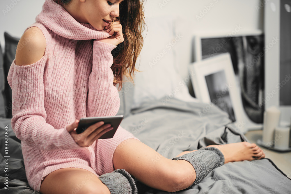 Girl sitting in her bed and using tablet at the morning Girl sitting in her bed and using tablet at the morning