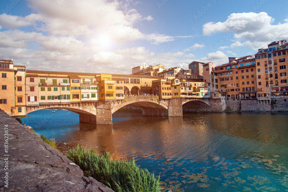 Beautiful city view with the famous medieval stone bridge Ponte Vecchio over the Arno river in Florence, Italy. Place of pilgrimage for tourists.