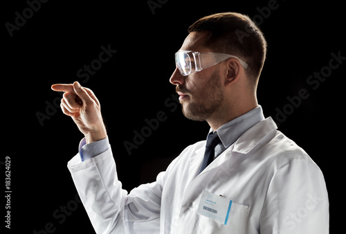 doctor or scientist in lab coat and safety glasses