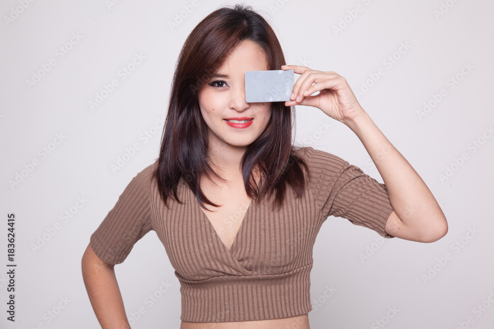 Young Asian woman with blank card over her eye. Young Asian woman with blank card over her eye.