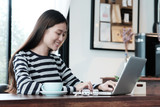 Beautiful asia woman using laptop computer with happy smiling face, work at home, people education, business and technology, casual lifestyle concept