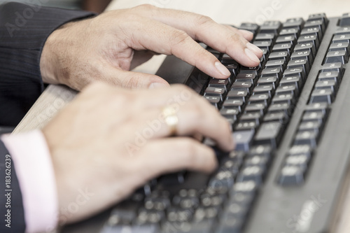 close-up hands of man on computer keyboard