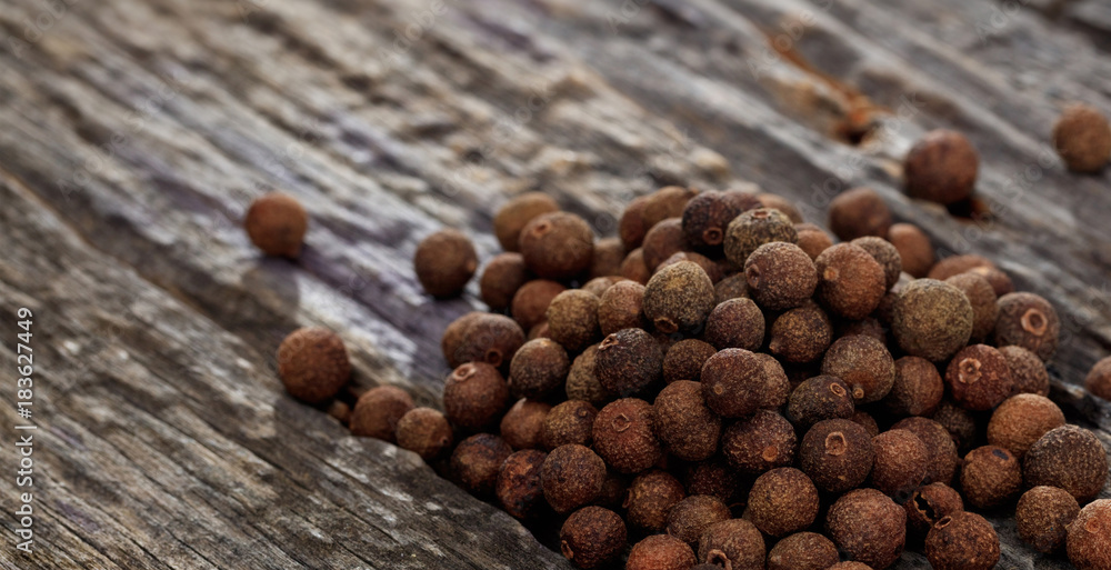 A heap of allspice, on wooden surface. Closeup view. - obrazy, fototapety, plakaty 