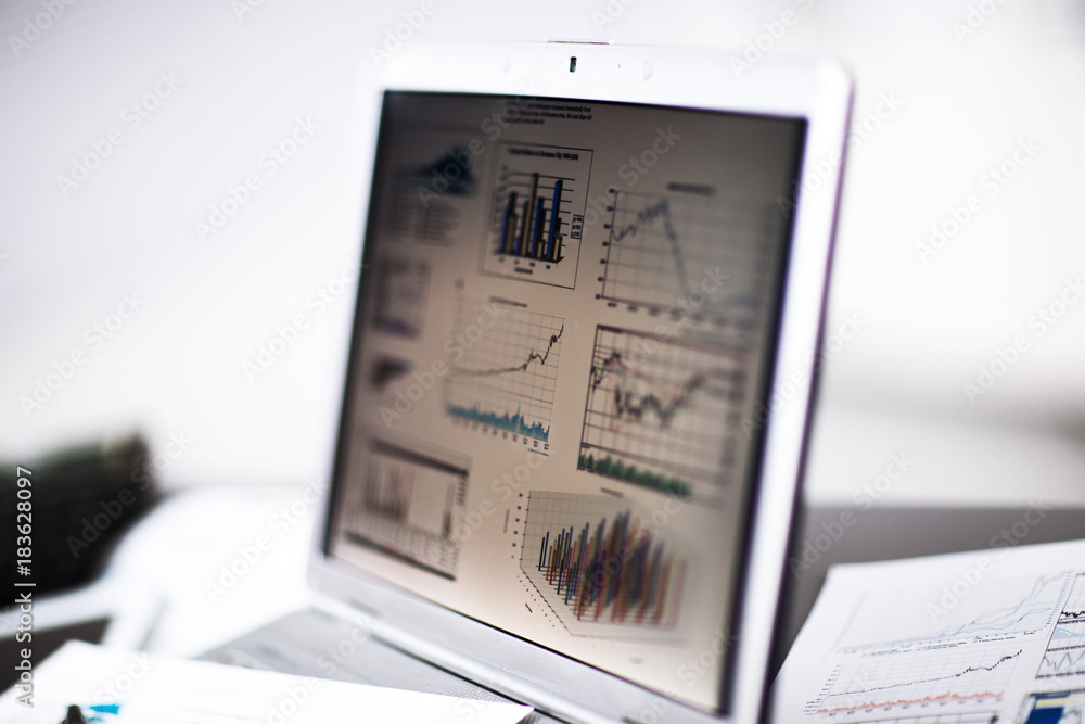 Obraz premium Businessman analyzing investment charts with laptop.