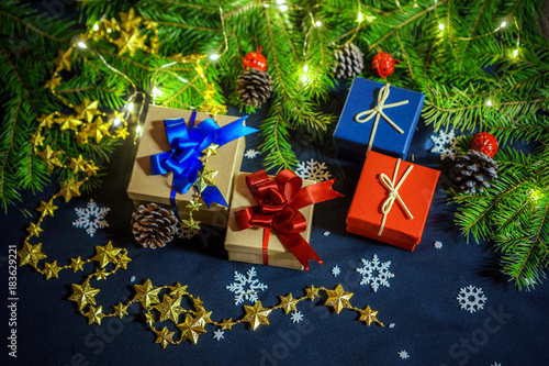 boxes with gifts on the background of FIR branches, cones and garlands photo