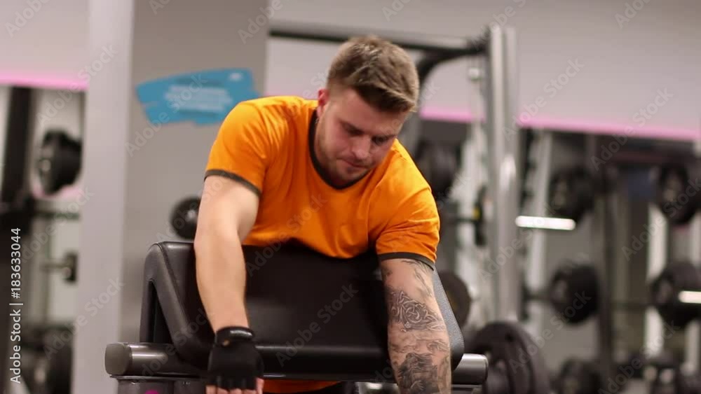 A man hard train biceps muscles in gym A man hard train biceps muscles in gym