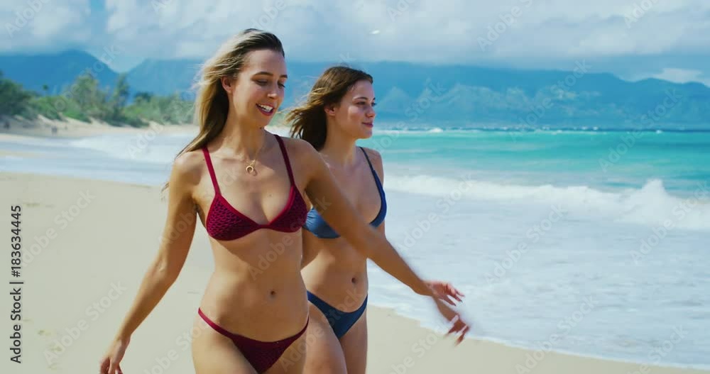 Beautiful girls enjoying relaxing walk on the beach Beautiful girls enjoying relaxing walk on the beach
