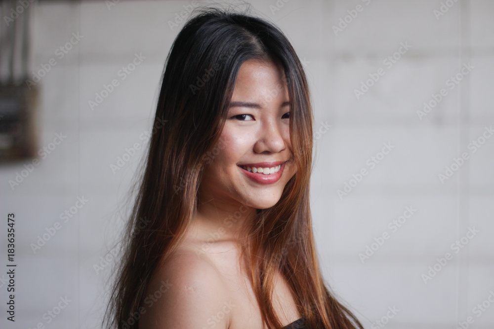 Portrait of a young beautiful long-hair asian woman smiling, white background