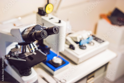 A sample preparation table in a laboratory with an optical microscope, ultrasonic cutter system and precision micrometer grinder polishing machine photo