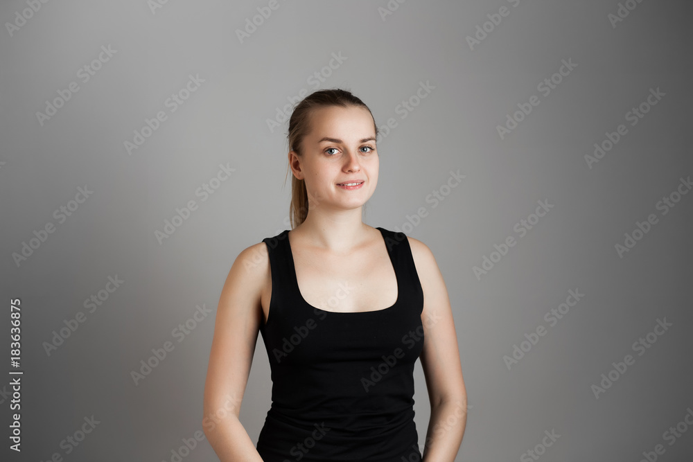 Portrait of young cheerful beautiful girl. With happy and relaxed face expression Smiling with teeth, looking at camera. Over grey background. Copy space. Portrait of young cheerful beautiful girl. With happy and relaxed face expression Smiling with teeth, looking at camera. Over grey background. Copy space.