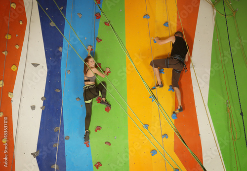 Young couple exercising in climbing gym