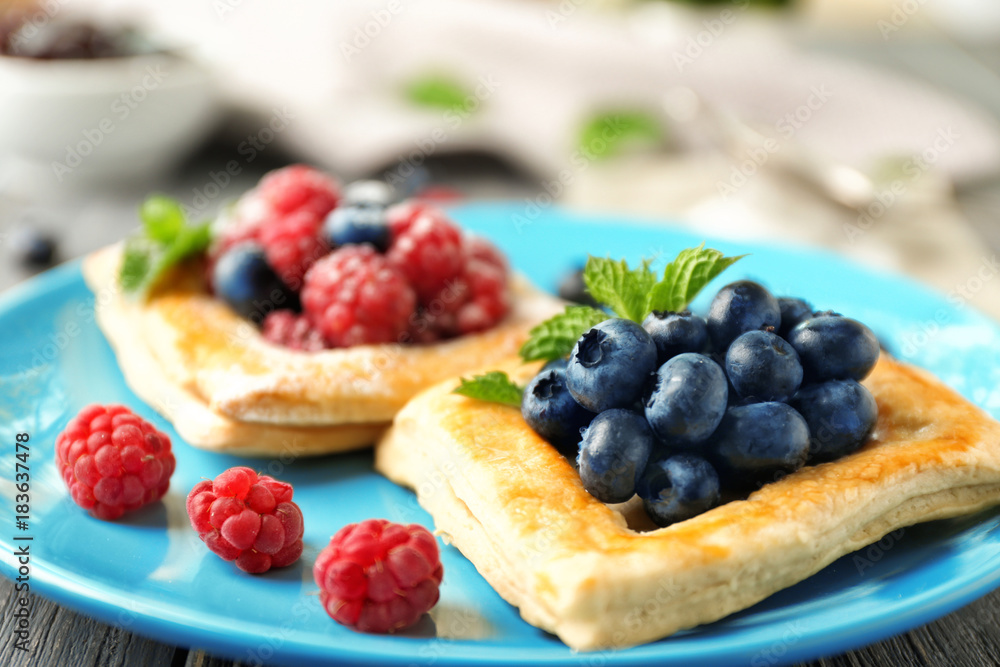 Fototapeta premium Yummy puff pastry with berries on plate