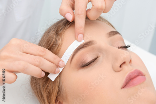 Photography Young woman having eyebrow correction procedure in beauty salon