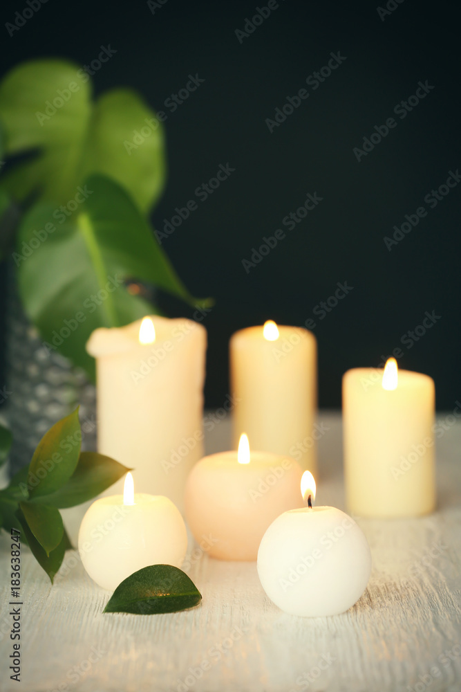 Burning candles on table against dark background Burning candles on table against dark background