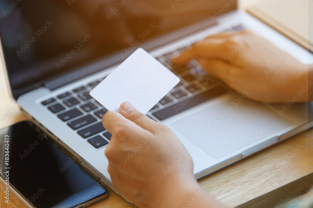 Hand holding credit card and using laptop. Online shopping. Hand holding credit card and using laptop. Online shopping.