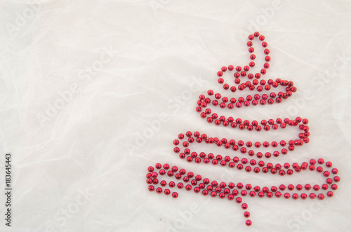 Christmas tree made of red pearls on a white background