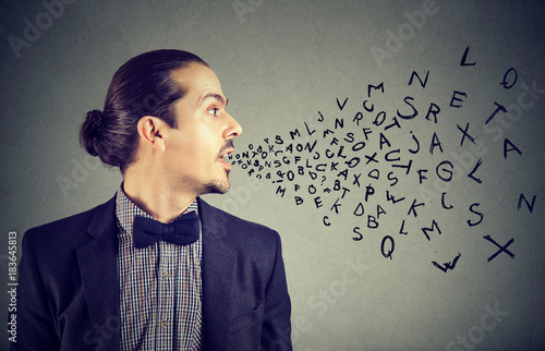 Man talking with alphabet letters coming out of his mouth. Communication, information, intelligence concept photo