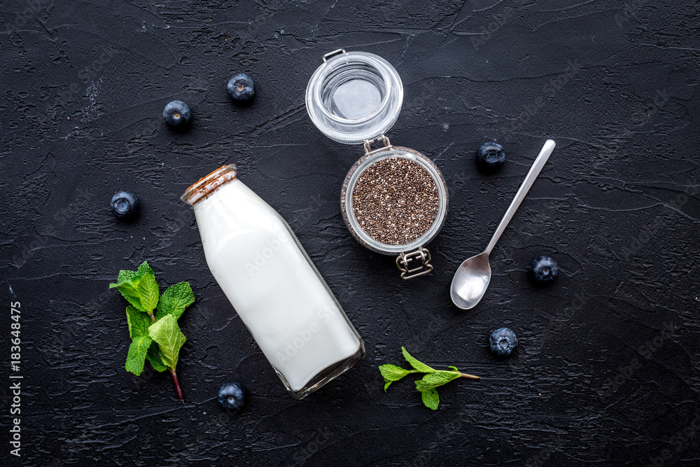 Light dessert with chia seeds, yogurt, blueberry and mint. Black background top view Light dessert with chia seeds, yogurt, blueberry and mint. Black background top view