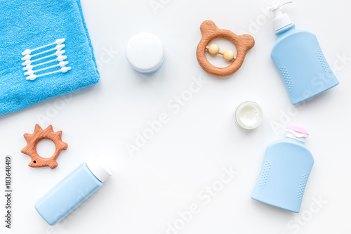 Natural bath cosmetics for kids. Bottles, towel and toys on white background top view copyspace