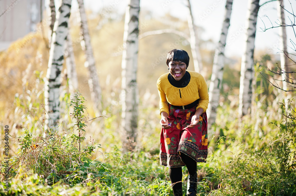 African american girl at yellow and red dress at golden autumn fall park. African american girl at yellow and red dress at golden autumn fall park.