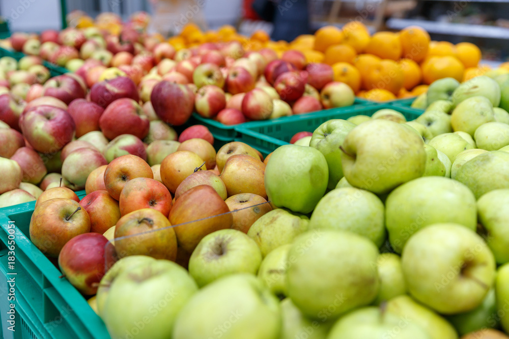 apples of different colors on display in a market