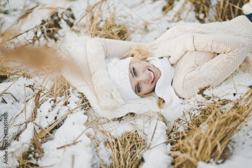 Portrait of a girl lying on snow covered dry grass 9160.