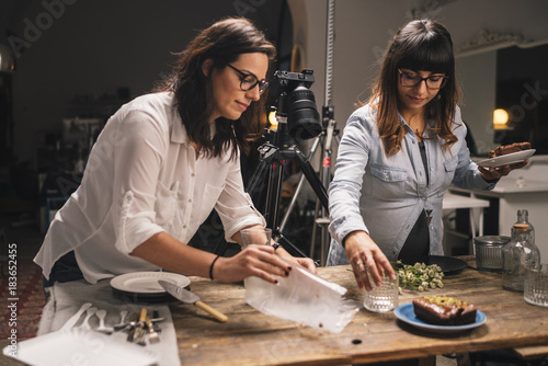 Pregnant woman with a colleague working on a food photo shoot photo