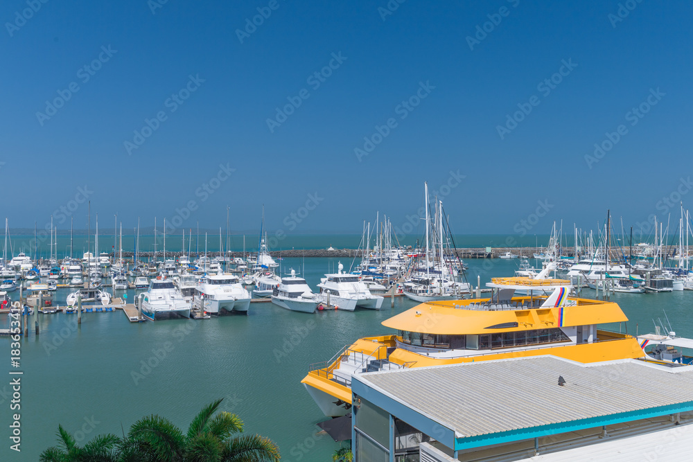 Yachthafen mit orangenem Ausflugsboot im Vordergrund