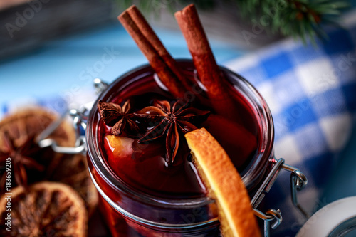 Mulled wine in a glass. Christmas hot mulled wine in a glass with spices and citrus fruit. Mulled wine with cinnamon, anise and orange. Christmas atmosphere