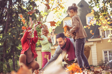 Happy family outside in colorful fall backyard.