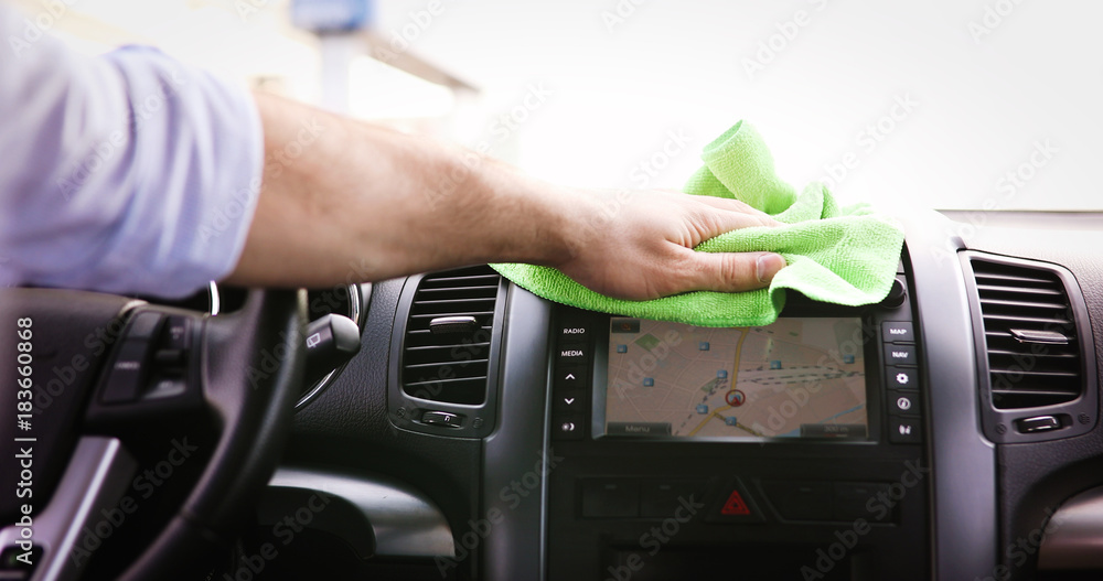Person cleaning car with microfiber clot and maintaining shine