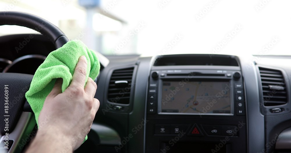 Hand cleaning car steering wheel with microfiber cloth