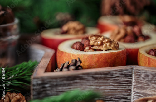 Baked apples with cinnamon on rustic background. Autumn or winter dessert. Closeup photo of a tasty baked apples with christmas decoration © Agnes
