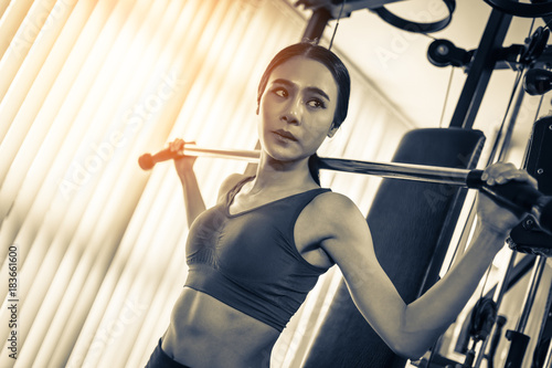 asian strong woman fit and firm healthy concept lifting dumbbell at gym
