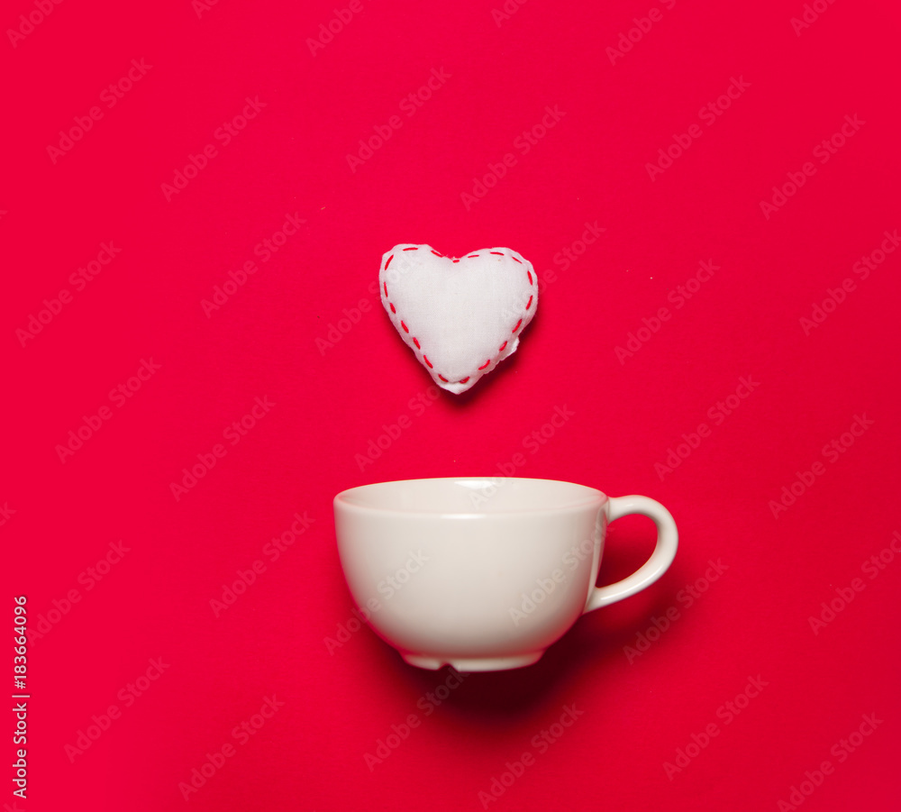 White cup and white heart shape toy