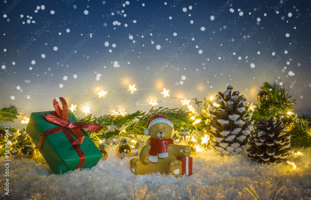 Fototapeta premium Christmas gift in the snow with teddy and fir branch, night sky and fir cones