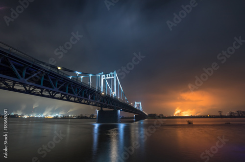 Nightshot Of Illuminated Historical Iron Bridge across the River Rhine at Krefeld Uerdingen View To Duisburg
