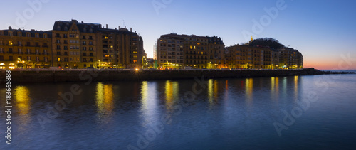 The lights of the city of San Sebastian are reflected in the sea water at night