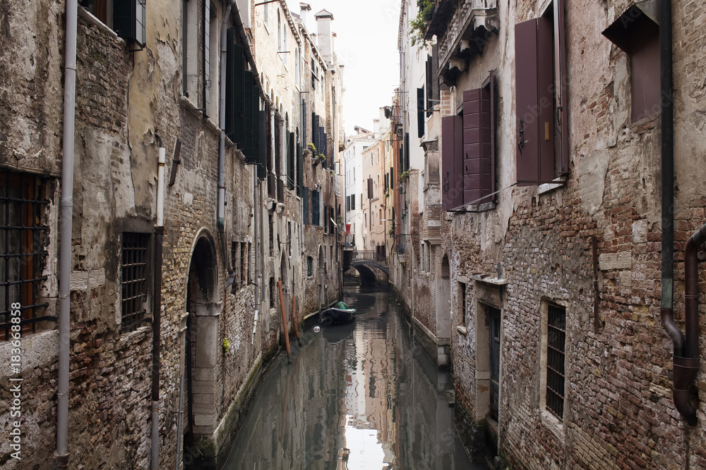 View of narrow canal and old, historical buildings in Venice / I