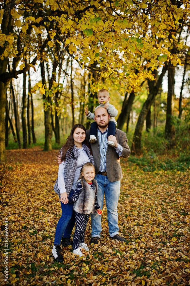 Happy caucasian family of mom dad and little girl with boy at majestic autumn fall forest. Happy caucasian family of mom dad and little girl with boy at majestic autumn fall forest.